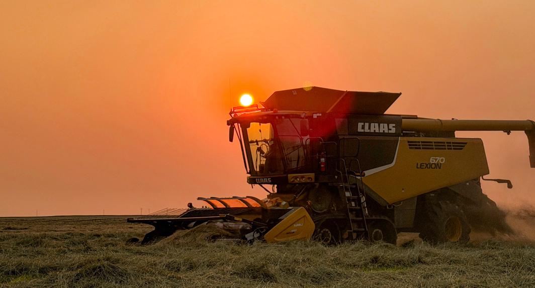 Machinery in a field at sunset