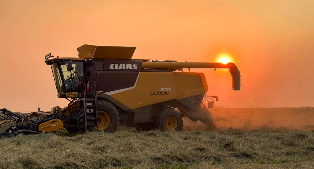 Machinery in a field at sunset