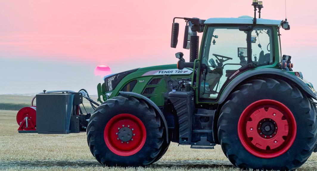 Machinery in a field at sunset